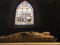 Tombe in de kloosterkapel met gebrandschilderd venster.