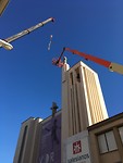 Een groot Mariabeeld wordt van de toren gehaald.