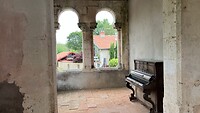 Een oude piano in het voorportaal van de kerk.