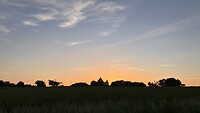 De opkomende zon achter de kapel in Beyries