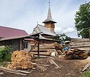 breb houten kerk naast houtzagerij met op voorgrond houten tinnen onbewerkt