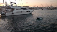 Yacht next to small rowing boat