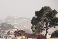 In de verte de Israëlische muur met daarachter de Westbank