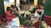 Bloembindsters aan het werk bij de Shwedagon Pagode.
