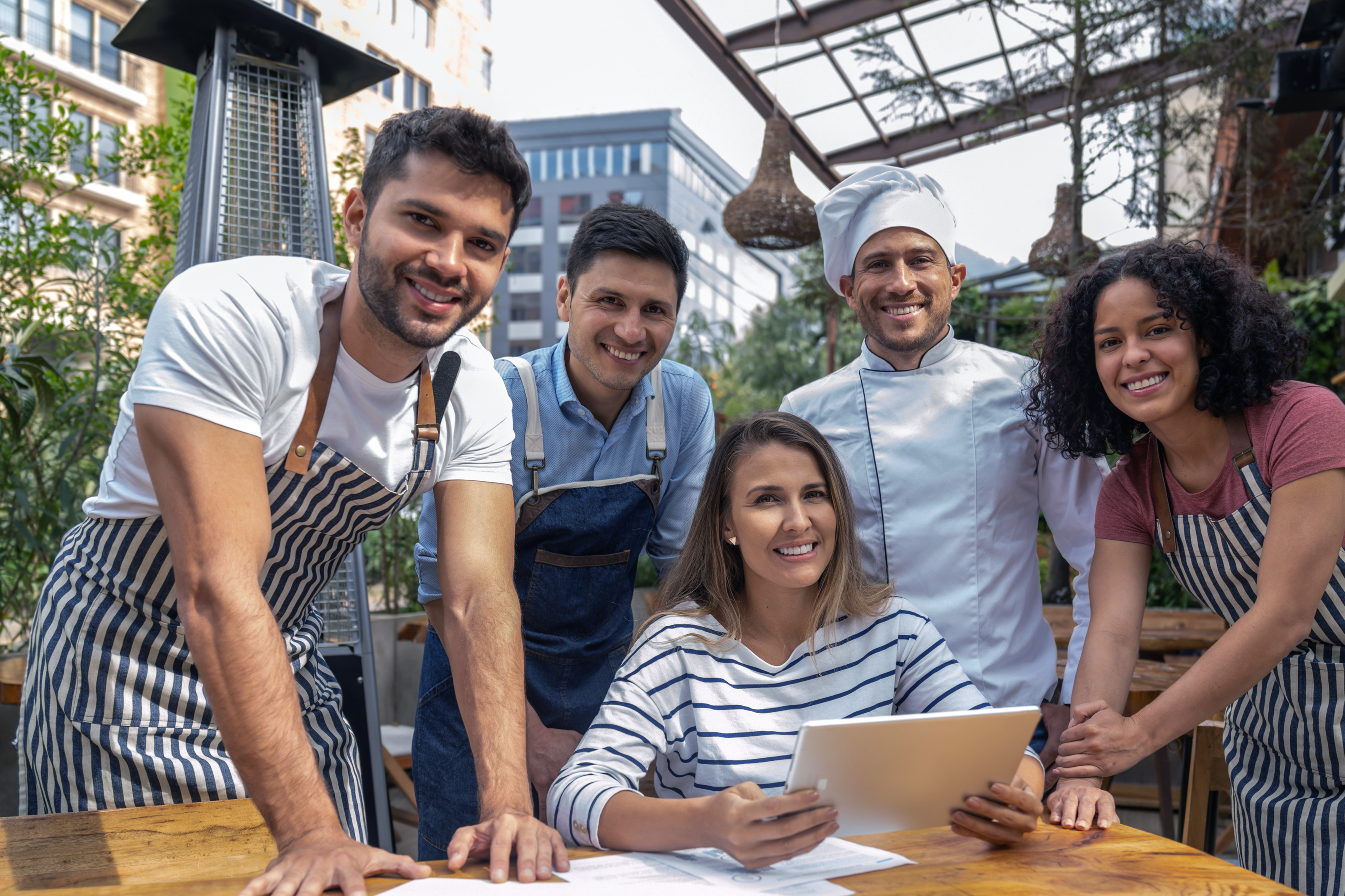 Restaurant labor management employees gathered around a table looking at a tablet