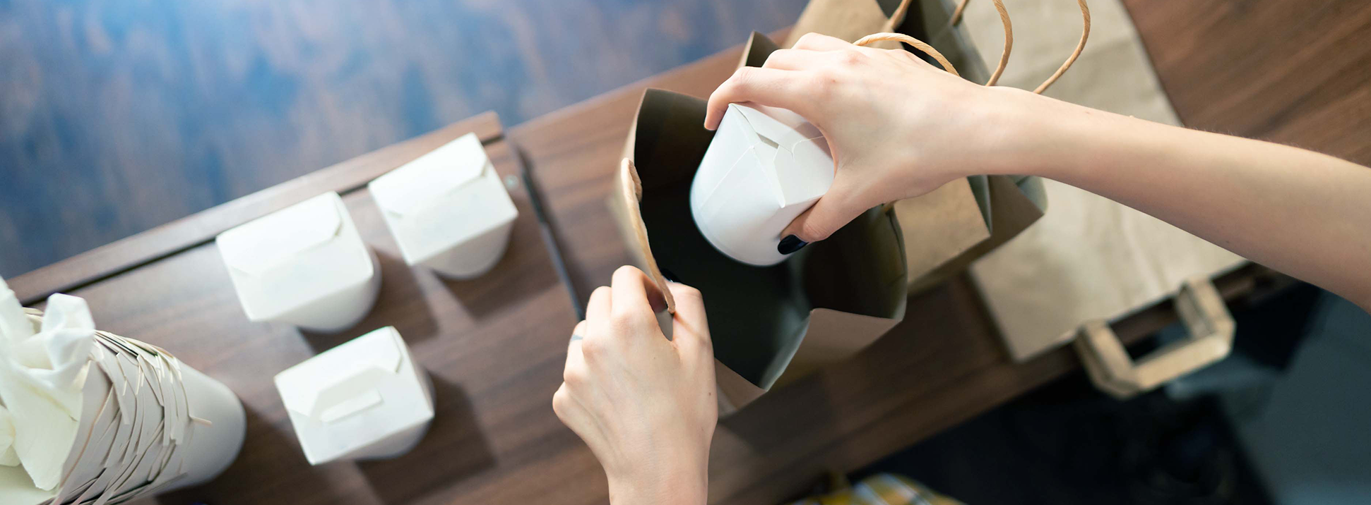 Online ordering system restaurant employee packing a takeout order