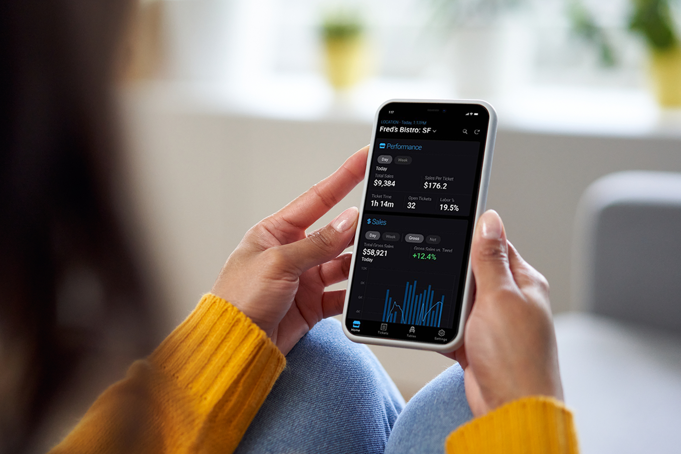 Quick-service POS owner using SkyTab back office mobile app on their phone