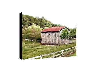 Living room canvas wall decor featuring wooden barn with cross on the side behind white farm fence