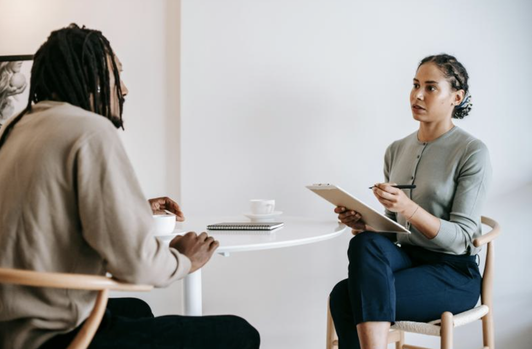 two people talking while holding documents