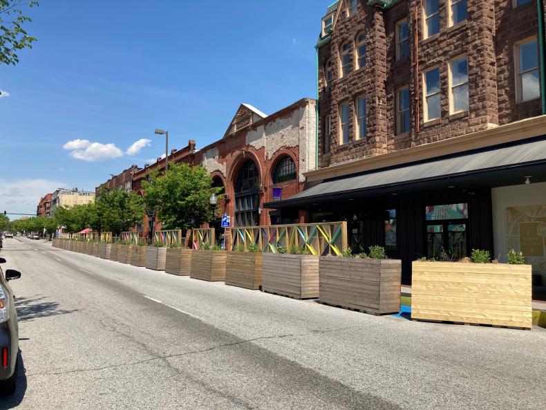 A row of planters separating the sidewalk from a street
