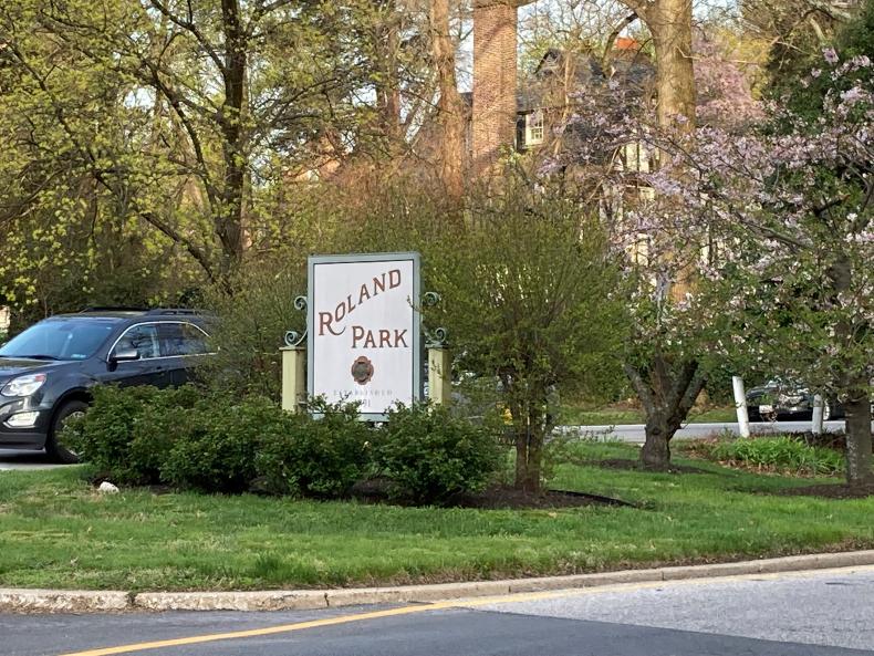 A park with a sign that reads "Roland Park"