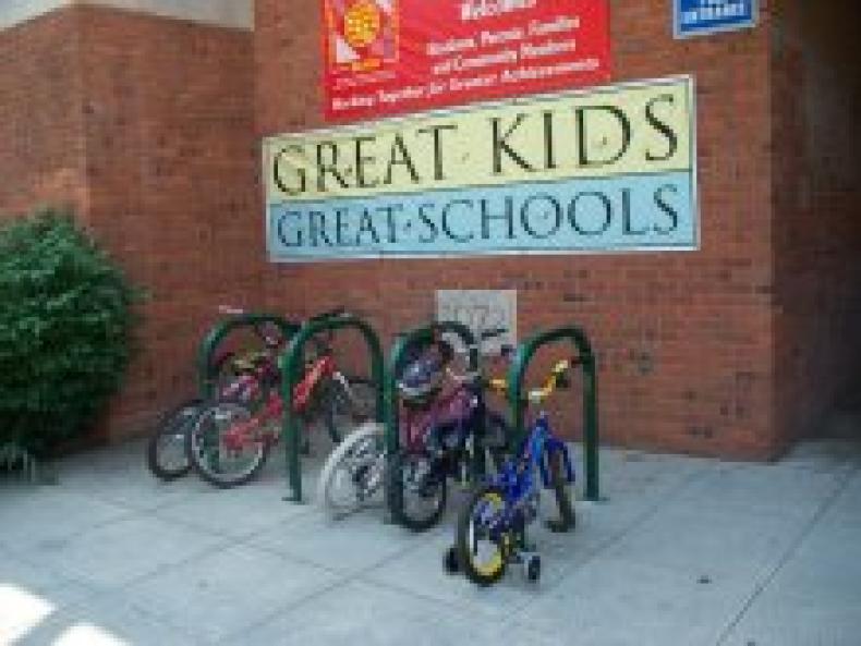 Bikes at a rack next to a school