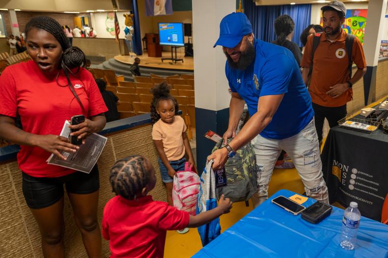 MONSE team members distributing backpacks to students at Bernard C. Harris