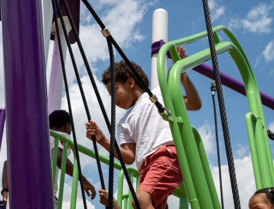 Young man playing on Mary Pat Clarke Playground