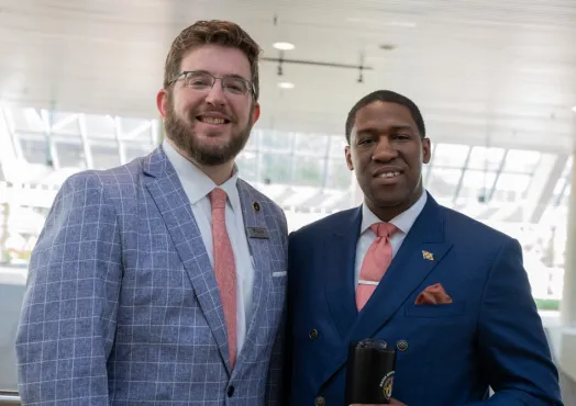 Two men standing in suits posing for a picture