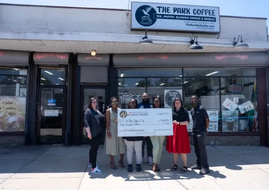 baltimore main streets team presents check to the park coffee store owner