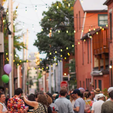 Block party in narrow street lined by rowhouses
