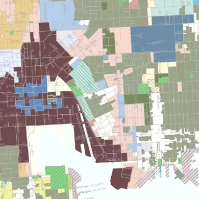 Muted overhead map of downtown Baltimore's street grid and parcels.