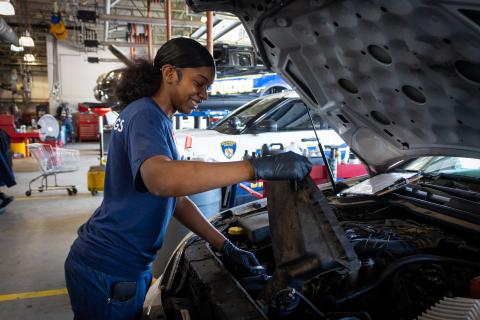 Work study student works on car engine