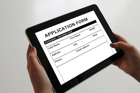 person filling out an application on a tablet