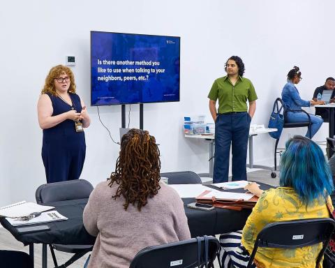 People in a room having a meeting with TV showing slides