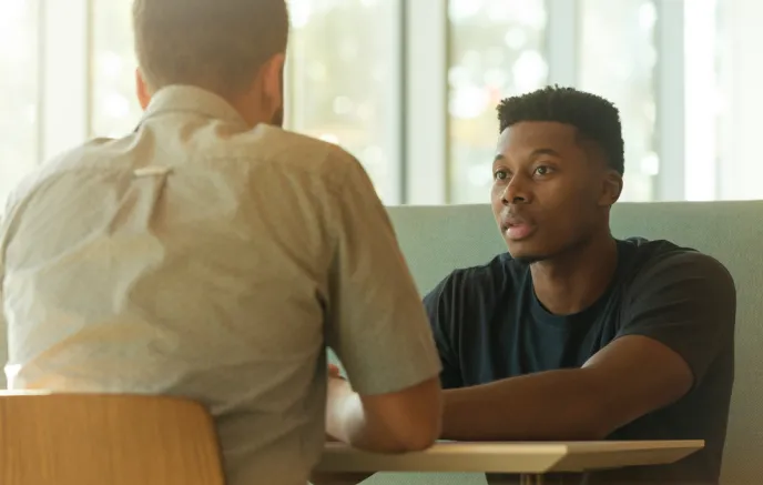 Two men talking while sitting at a table