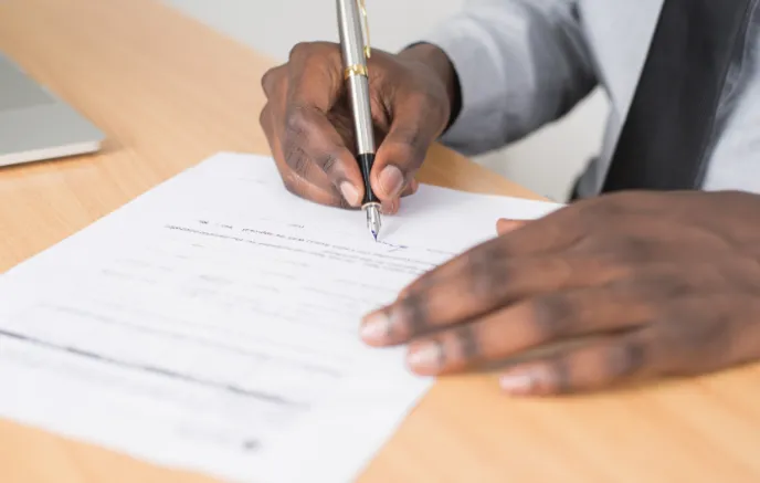 Person Holding Gray Twist Pen Writing on a Paper