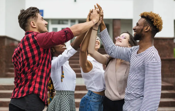 Group of young adults high fiving