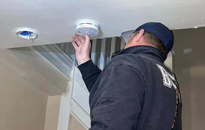 Firefighter checking smoke alarm