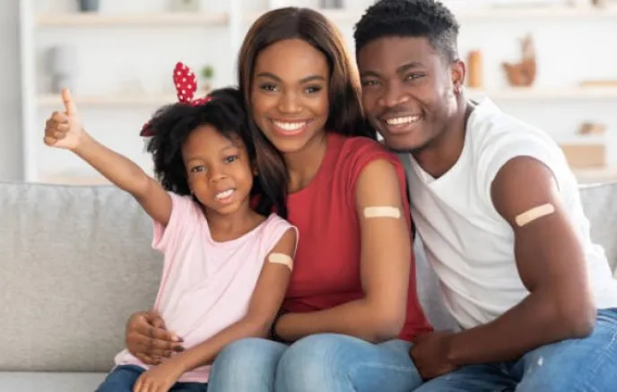 Family of three smiling on couch