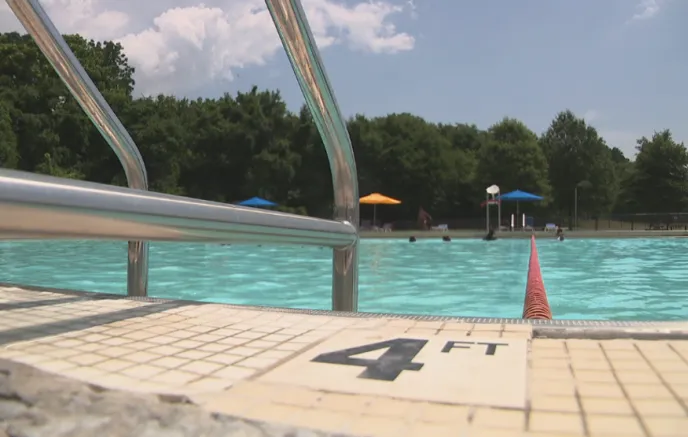 A pool with a ladder and a 4 Feet logo on the ledge