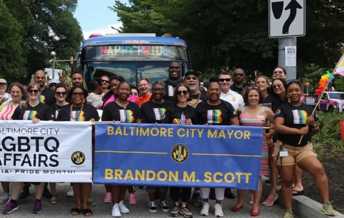 LGBTQ supporters holding a mayor banner