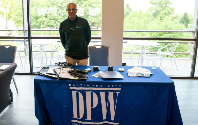 Department of Public Works employee standing at an application table