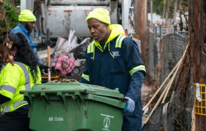 city workers picking up trash cans