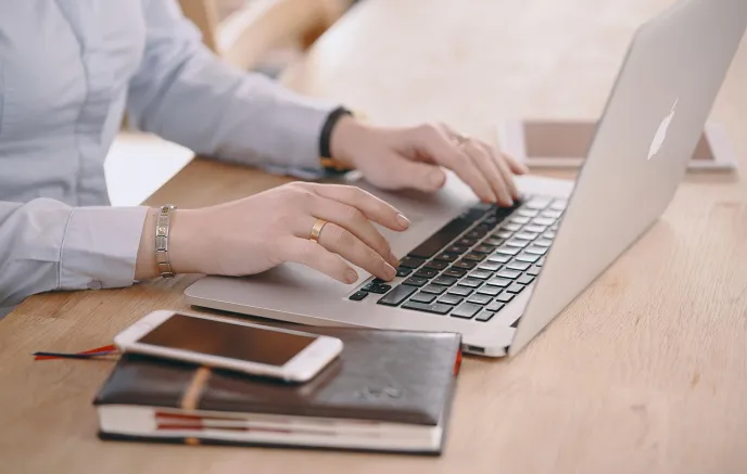 hands of a woman sitting at a laptop computer