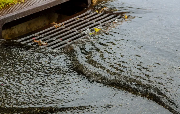 water gushing from storm sewer following very heavy