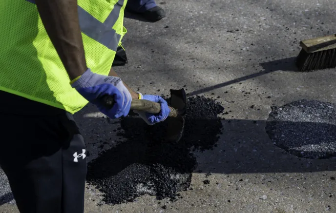 DOT worker repairing road