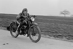 Boy Racing Old Motorcycle by Jurgen Dopatka