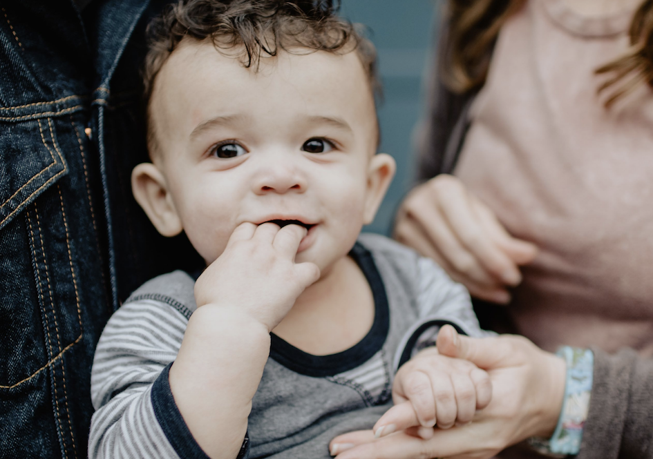 Toddler holding hands with caregiver