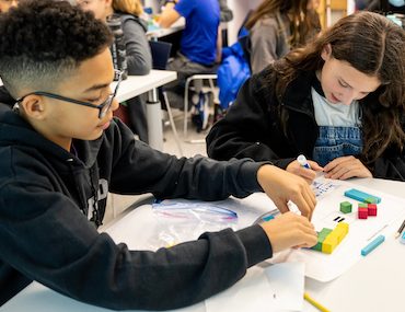 Two students working together on math using colorful math manipulatives