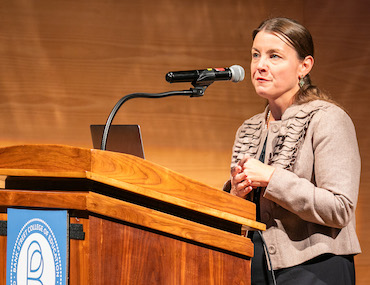 Dr. Lauren Madden speaking at the podium at the 2026 Barbara Biber Convocation
