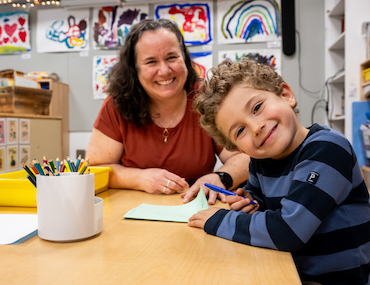 Educator working with young student in a classroom