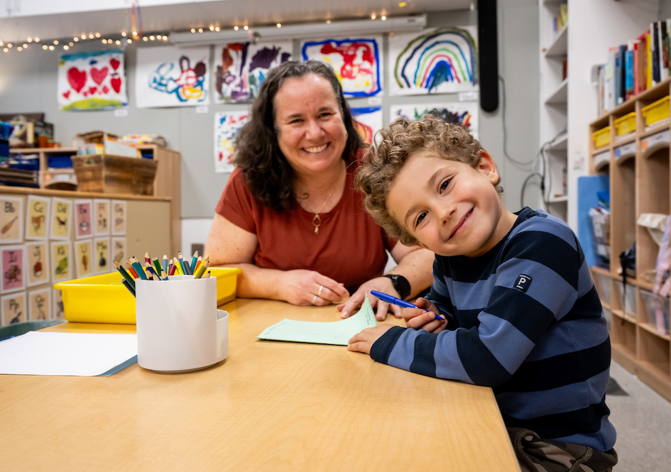 Educator working with young student in a classroom