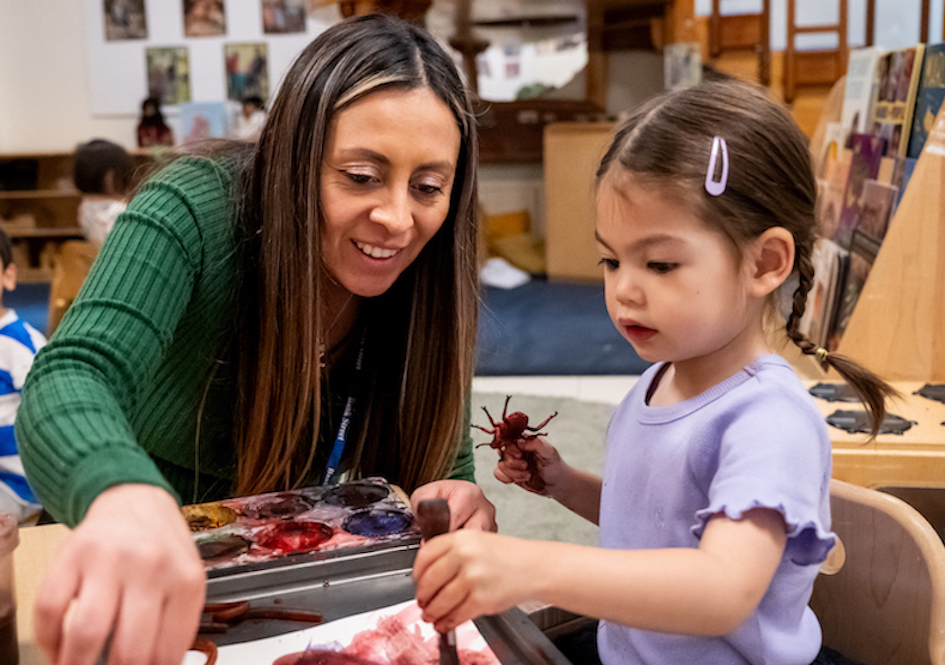 Teacher and young child doing an art/science project with paint in a classroom