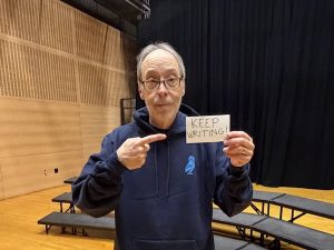 Bank Street 2026 Writer-in-Residence Dan Gutman holding a "Keep Writing!" sign