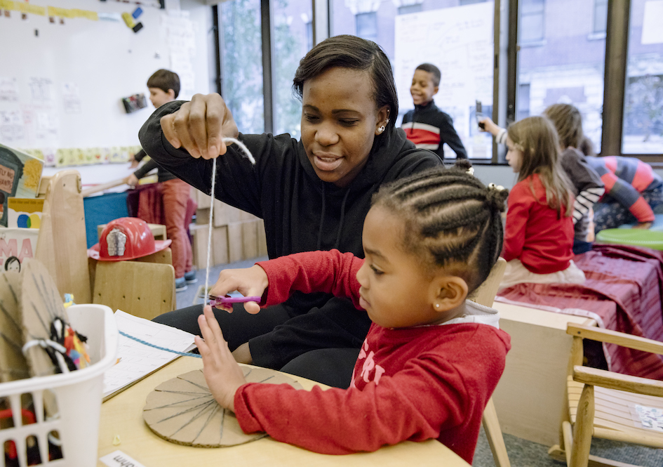 Teacher helps child with art project