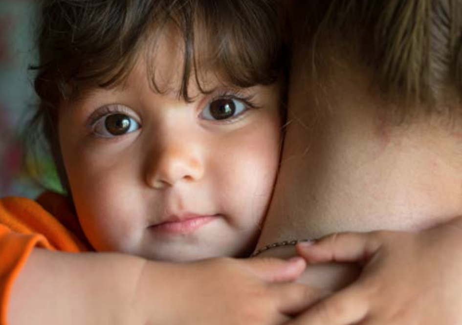 Young child hugging caregiver