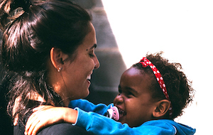 Caregiver holding young child smiling