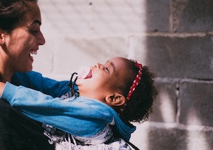 Adult holding smiling toddler