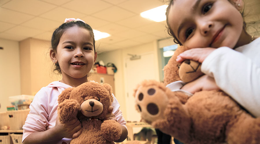 Two young children holding teddy bears